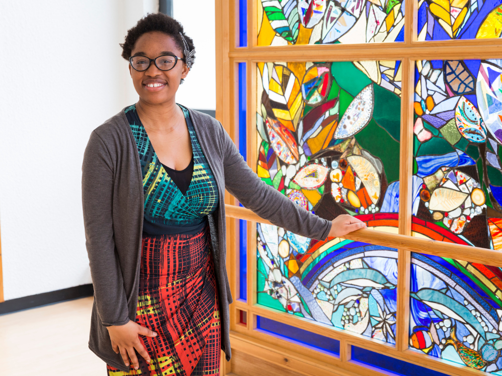 A student in front of a stained glass window