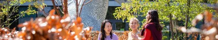 A group of three female students chat at the Easter Bush campus
