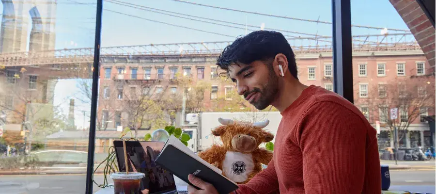 A student based in New York reads from a University branded notebook
