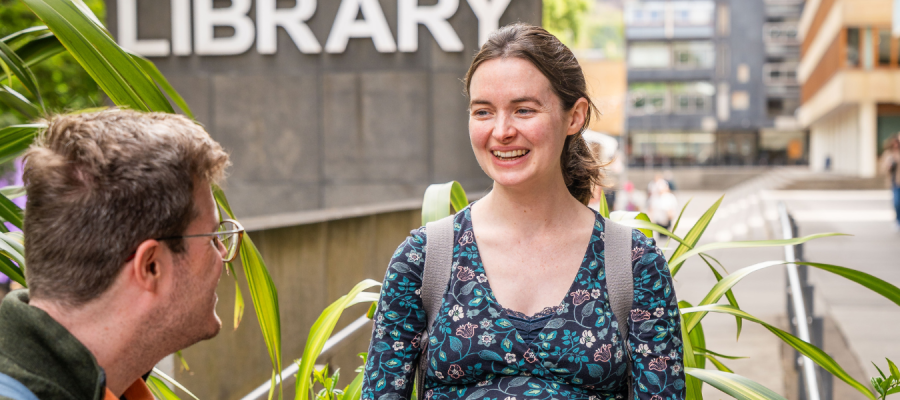 A woman smiling outside the library