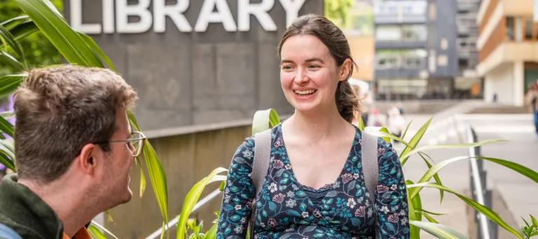 A woman smiling outside the library